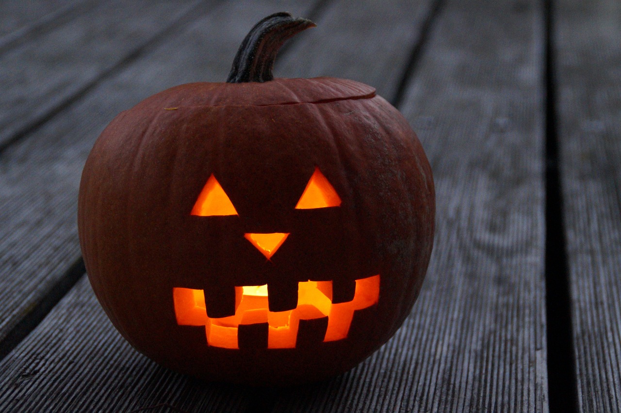 a carved pumpkin sitting on top of a wooden table, a picture, pexels, big evil grin, candlelit, profile shot, 2070