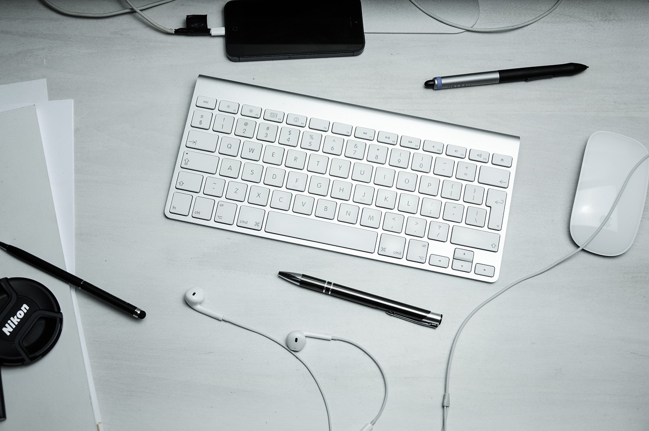a computer keyboard sitting on top of a white desk, pexels, earbuds, modern very sharp photo, knolling, white and silver