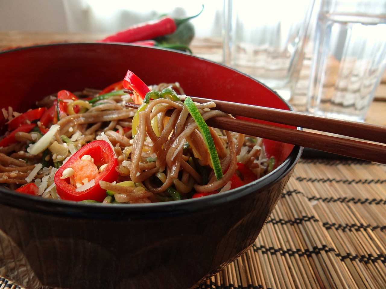 a close up of a bowl of food with chopsticks, by Caroline Mytinger, flickr, salad, in a red dish, noodles, professionally post-processed