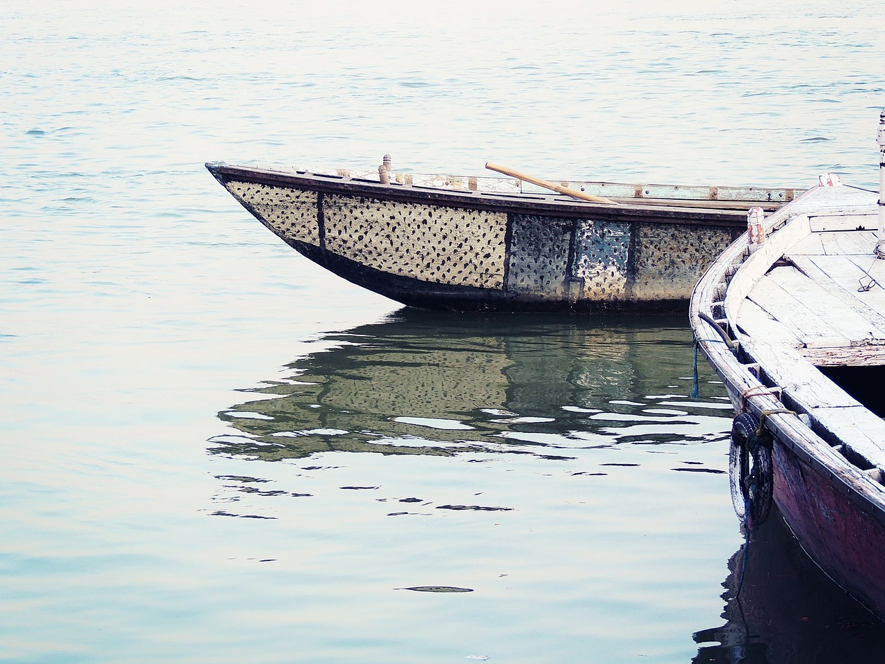 a couple of boats floating on top of a body of water, a picture, pexels, folk art, high key detailed, reflective scales, old color photo, istock