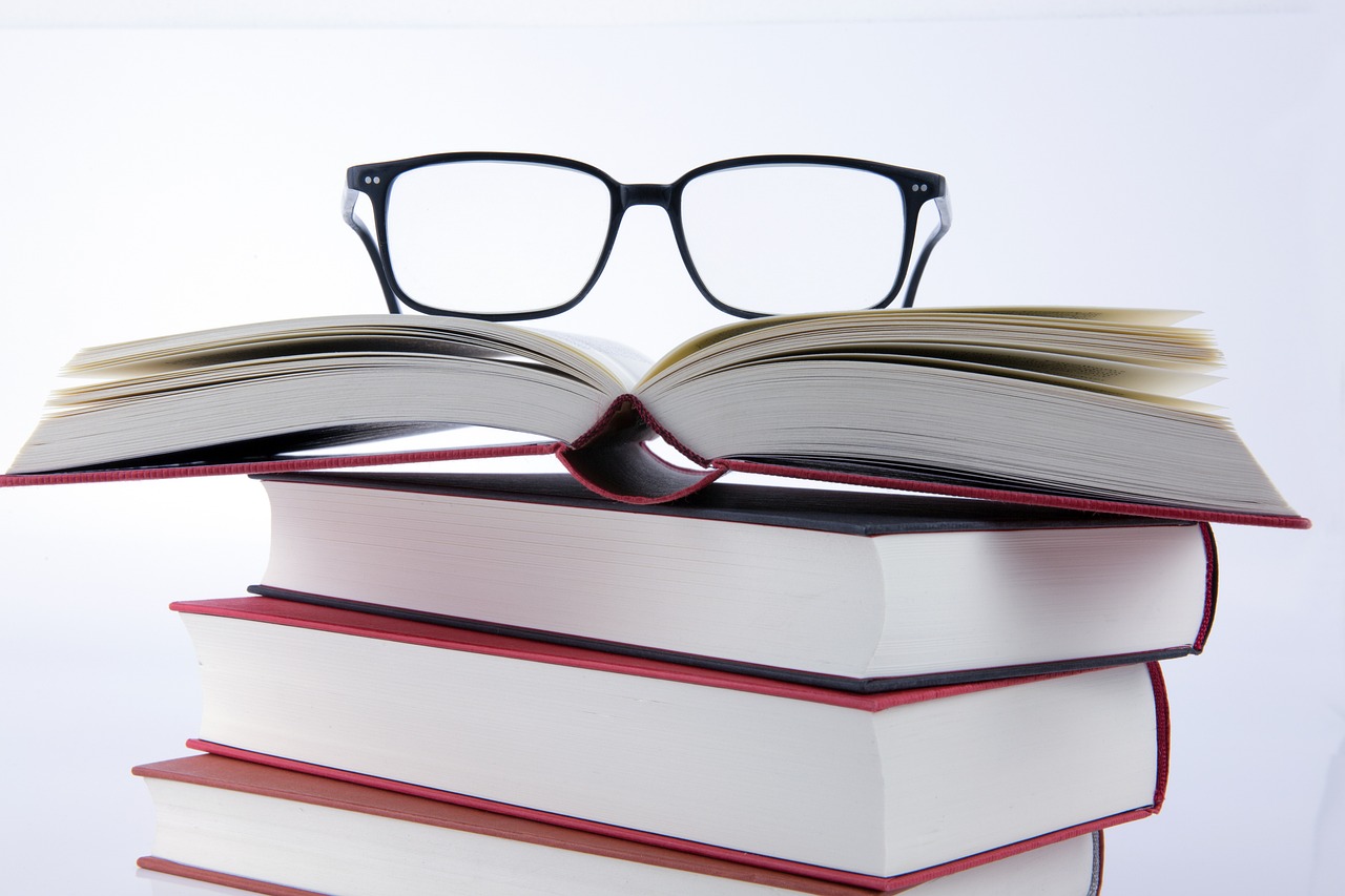 a stack of books with glasses on top of them, a picture, by Dietmar Damerau, shutterstock, wearing black frame glasses, stock photo, low angle photo, maintenance photo