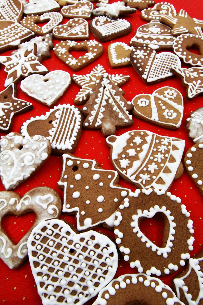 a table topped with lots of cookies covered in icing, a photo, pexels, folk art, red brown and white color scheme, beautiful shapes, bells, hearts