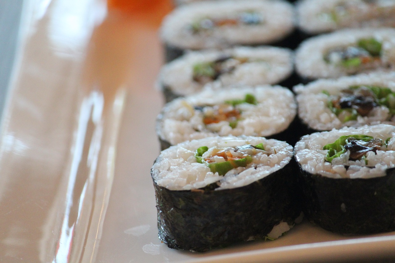 a white plate topped with sushi and chopsticks, a picture, flickr, mingei, closeup photo, in a row, korean, kimitake yoshioka
