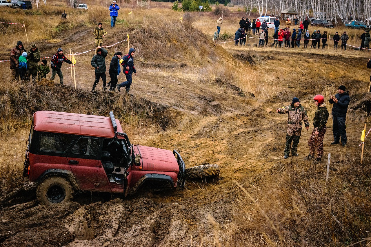 a red jeep is stuck in the mud, a photo, by Aleksander Gierymski, auto-destructive art, in a race competition, long shot wide shot full shot, anna nikonova, guardrail