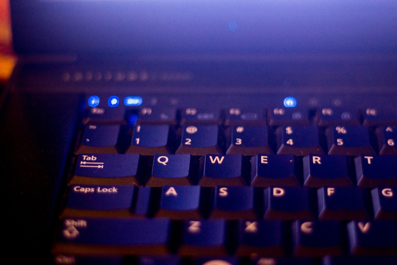 a close up of a blue computer keyboard, a screenshot, by Matt Stewart, flickr, evening lights, laptops, low - angle shot, purple glow