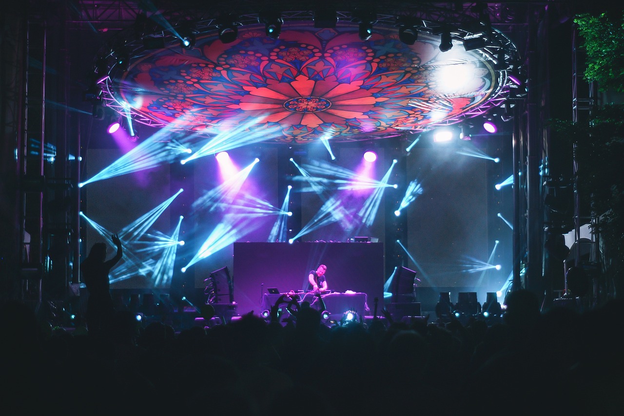 a group of people standing on top of a stage, a picture, by Byron Galvez, pexels, light and space, infected mushroom, giant lotus mandala, violet lighting, 2 0 1 4