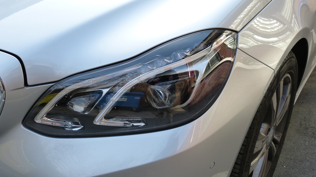 a close up of a car's headlight on a street, a picture, tumblr, photorealism, clear curvy details, electric, sunny light, gm