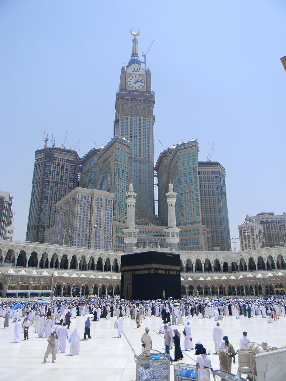 a large group of people standing around a building, a picture, by Sheikh Hamdullah, flickr, hurufiyya, mecca, two giant towers, vacation photo, inside view