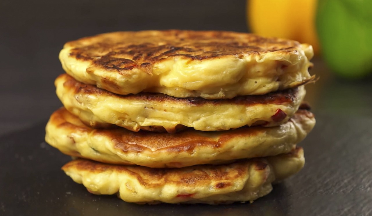 a stack of pancakes sitting on top of a table, by Tom Bonson, yellow and red, video, melted cheese, meni chatzipanagiotou