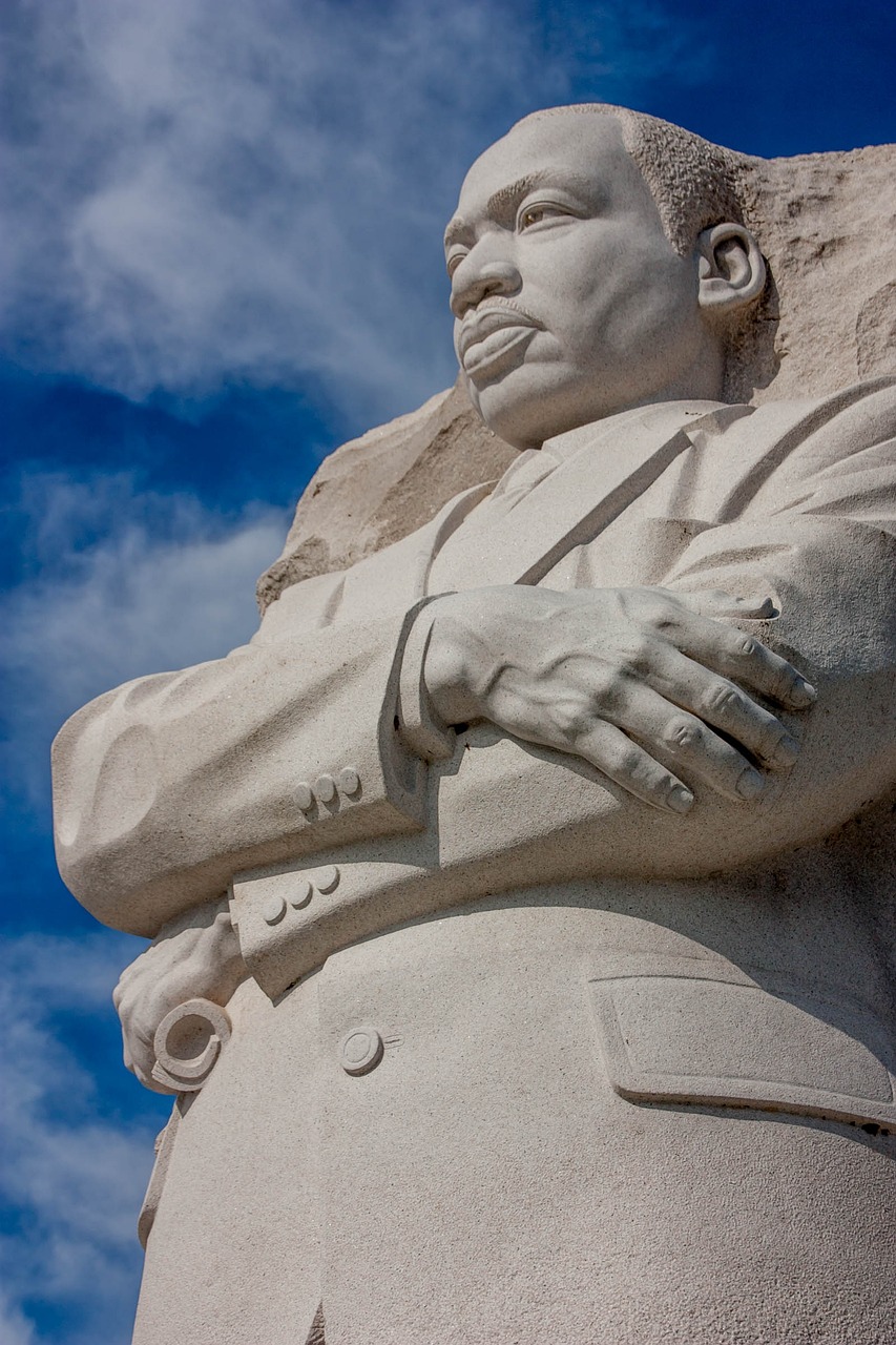 a statue of martin luther in front of a blue sky, by Dave Melvin, figurativism, martin luther king, closeup of hand, amazing concrete sculpture, smooth detailed