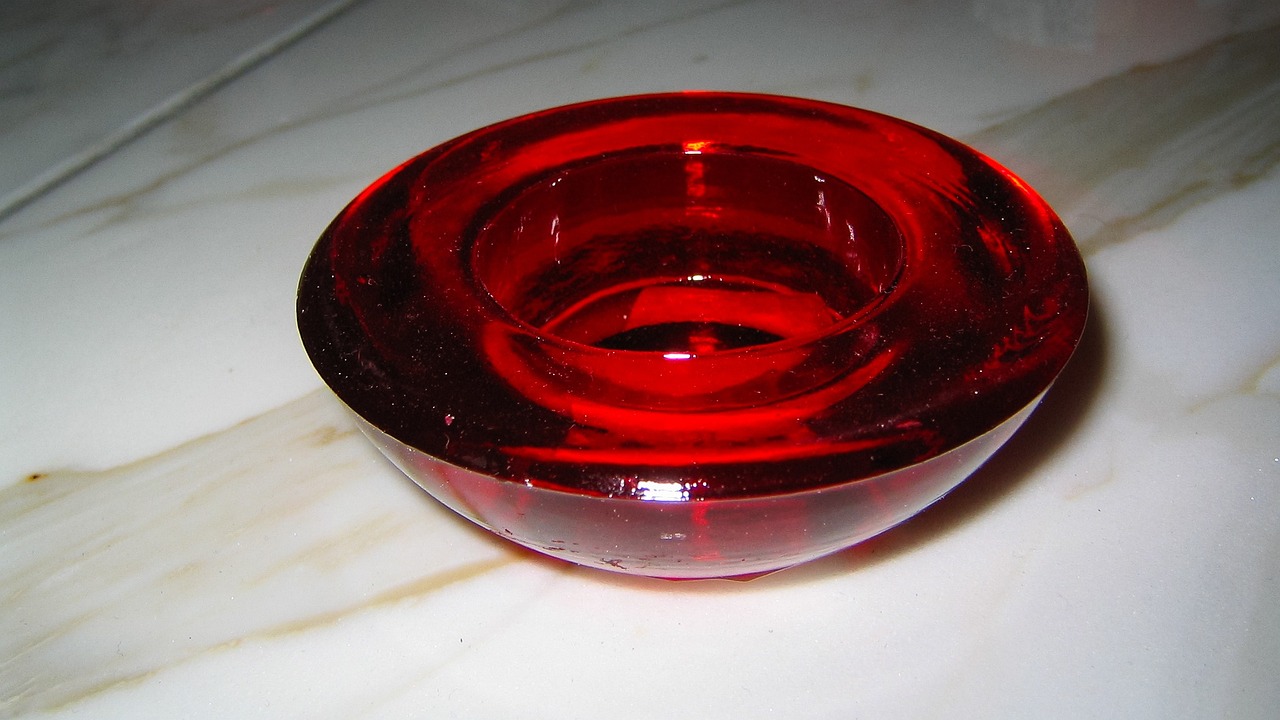 a close up of a red glass on a table, by Eugeniusz Zak, flickr, ashtray, ebay, russian, on a candle holder