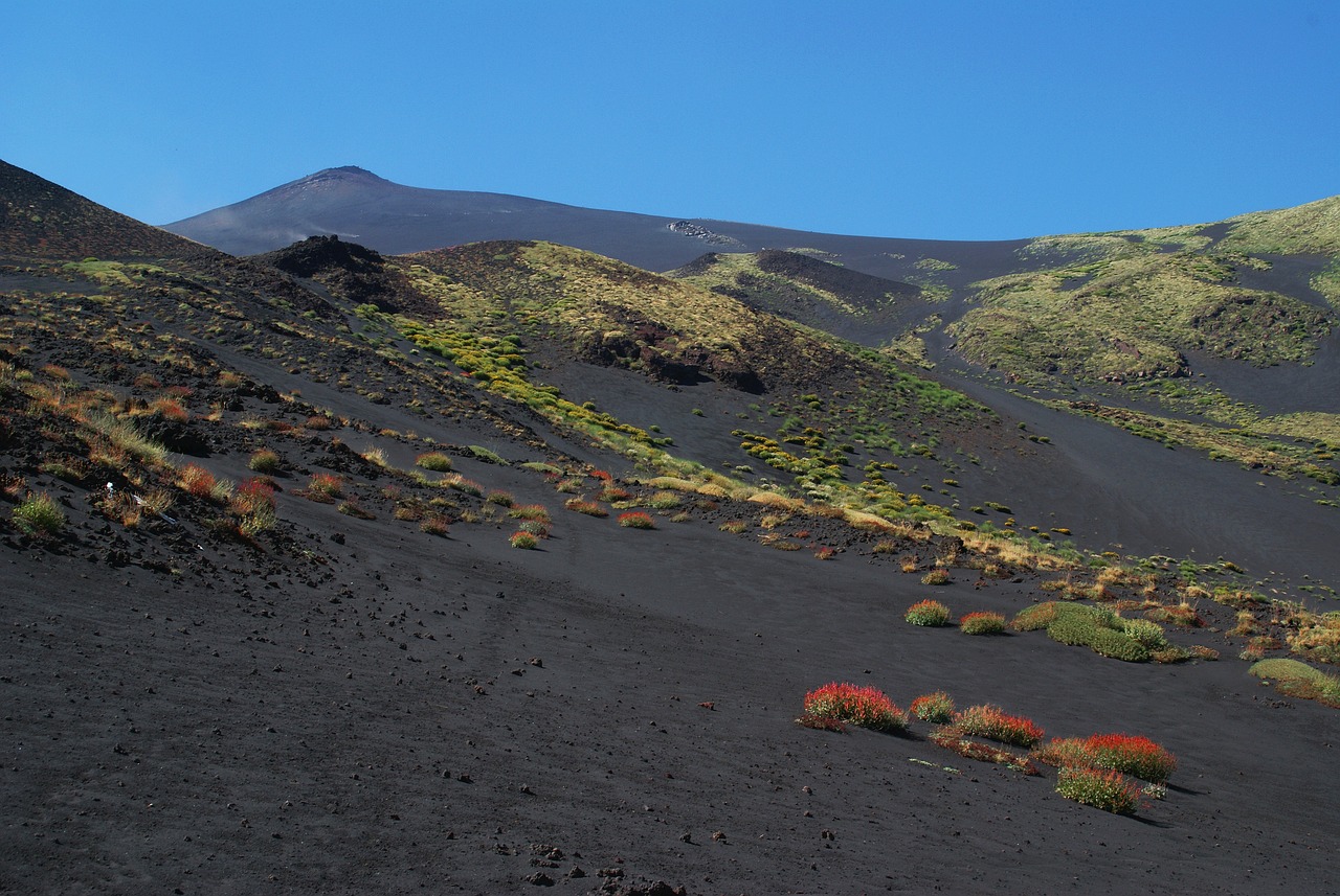 a person riding a horse on the side of a mountain, by Carlo Martini, flickr, sōsaku hanga, body with black and red lava, flora-lush-crater, sicilian, blue sand