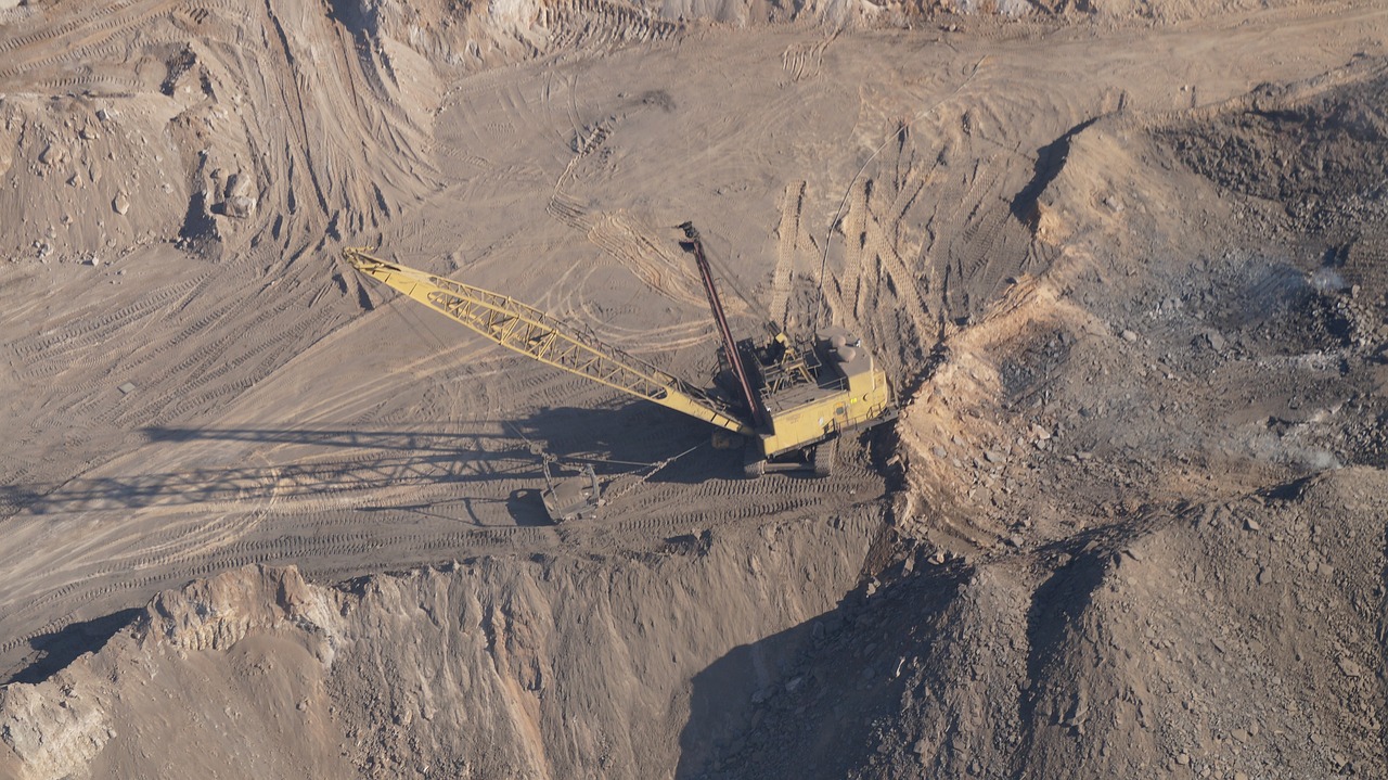 a large crane that is sitting in the dirt, pexels, “ aerial view of a mountain, broken machinery, coal dust, 2 0 1 0 photo
