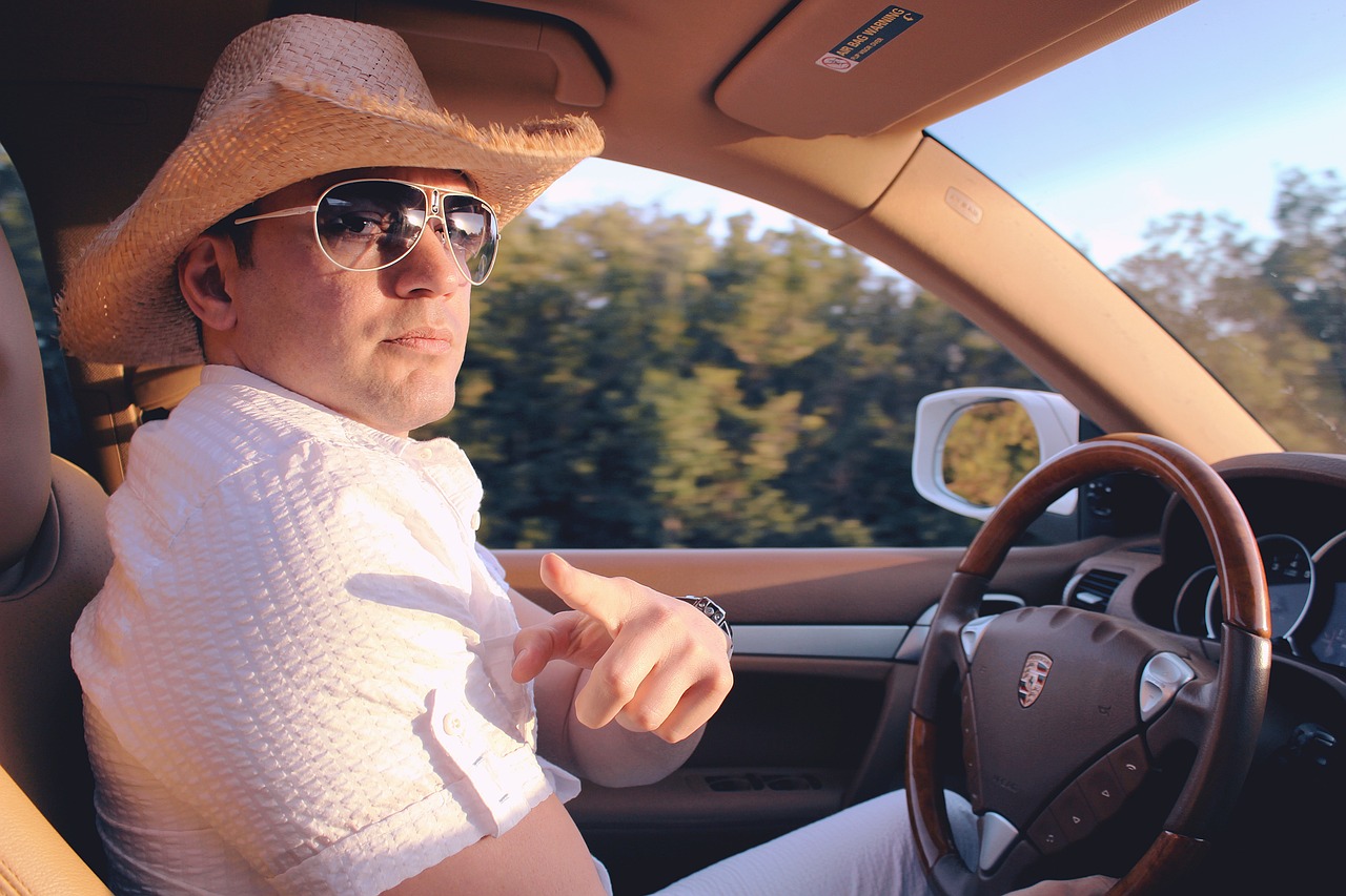 a man in a hat and sunglasses driving a car, dustin panzino, white cowboy hat, influencer, napa
