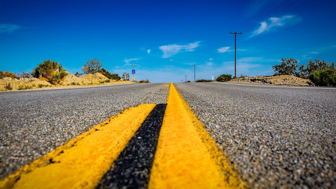 a yellow line in the middle of a road, a picture, by Richard Carline, route 6 6, low angle photography, yellow and blue, southern california