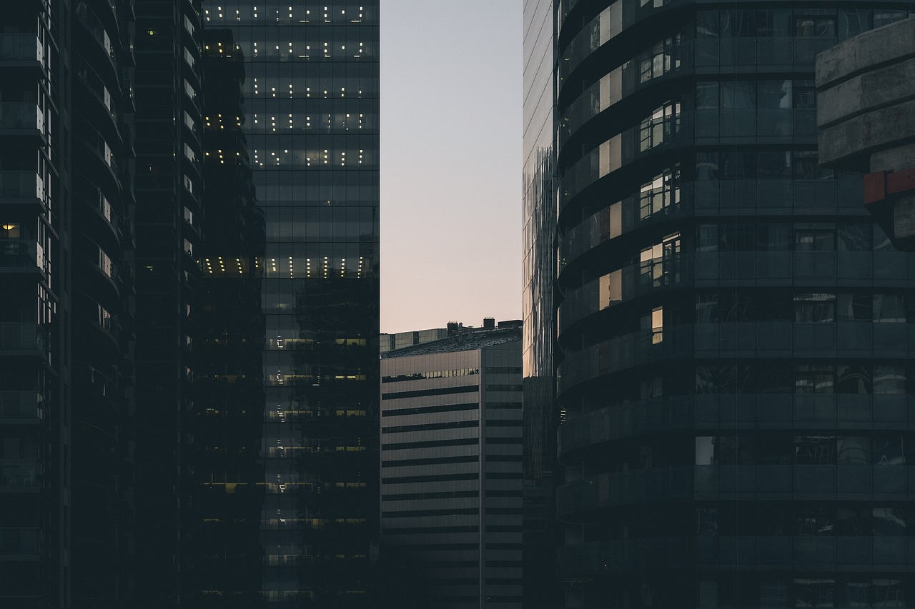 a couple of tall buildings next to each other, a picture, unsplash contest winner, corner office background, early morning mood, hq 4k phone wallpaper, tall obsidian architecture