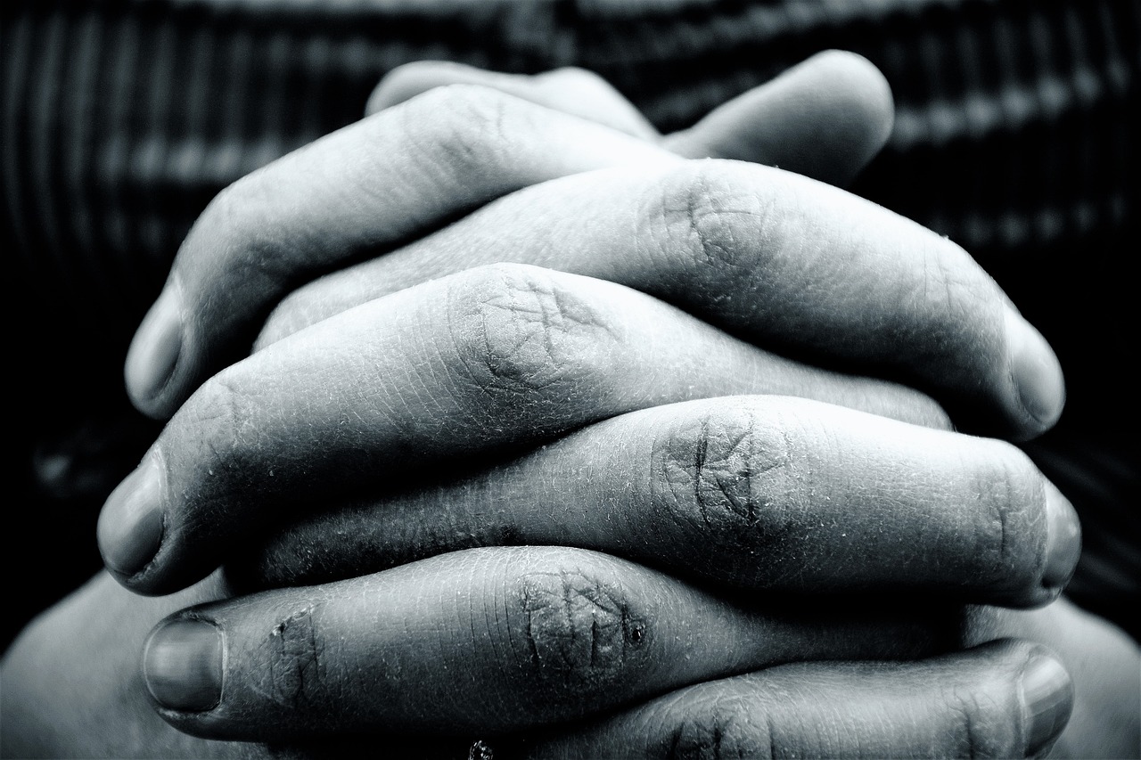 a close up of a person holding their hands, a black and white photo, prayer hands, stacked, istockphoto, lomo