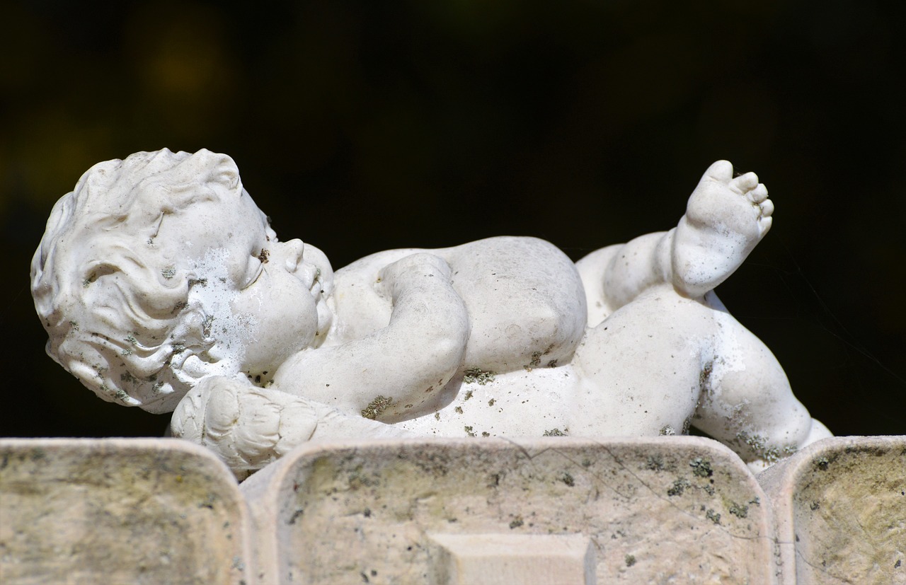 a statue of a baby laying on top of a wall, a statue, inspired by Correggio, parapets, tiny details, symbology, gargoyle