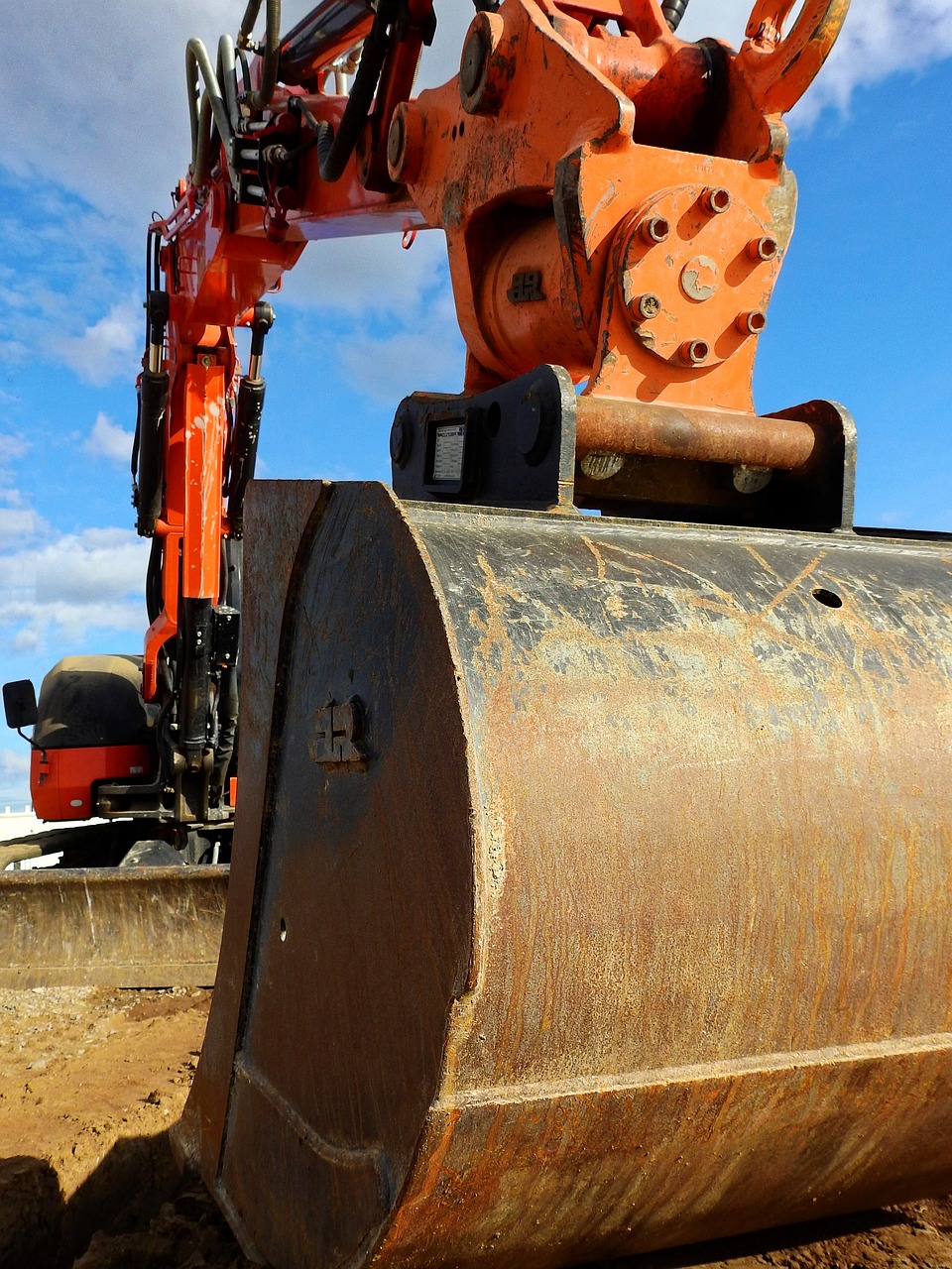 a large orange machine sitting on top of a dirt field, by Wayne England, pixabay, huge black round hole, close up angle, pipe, ground breaking