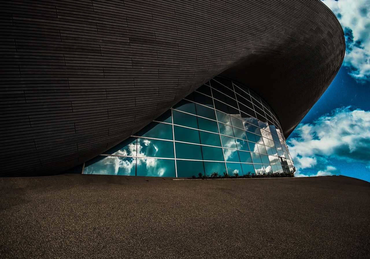 a man riding a skateboard up the side of a building, a picture, inspired by Zaha Hadid, unsplash contest winner, modernism, wide angle landscape photography, in a futuristic arena, england, hdr refractions