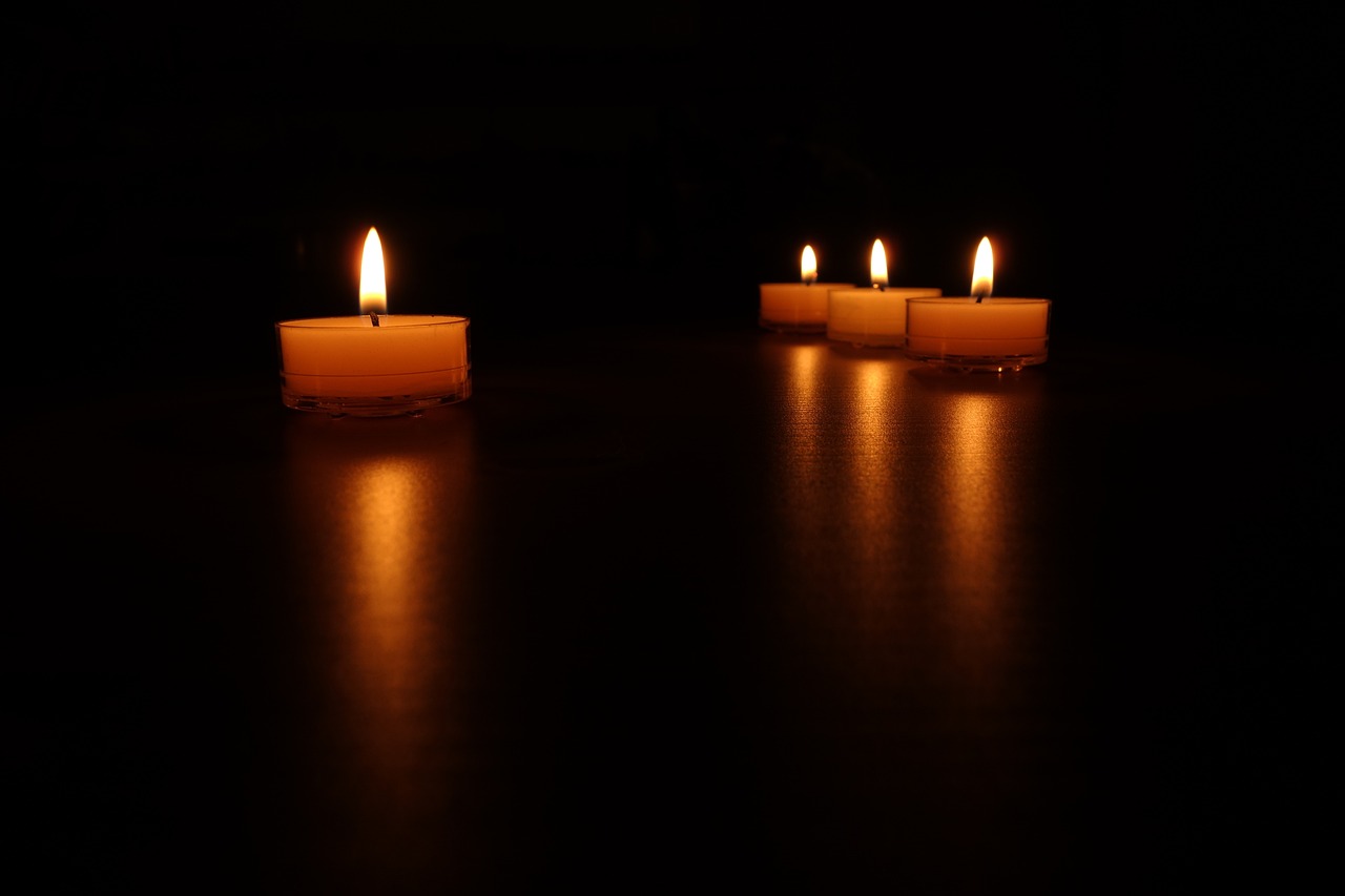 three lit candles sitting on a table in the dark, a picture, night photo, in a row, low angle photo