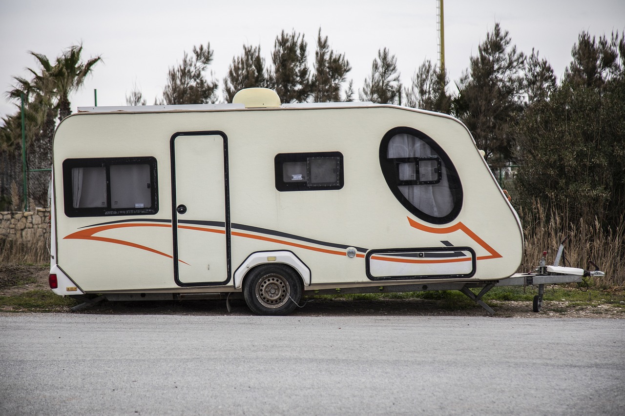 an rv parked on the side of the road, a photo, by Etienne Delessert, shutterstock, folk art, 3/4 side view, very sparse detail, caravan, stock photo