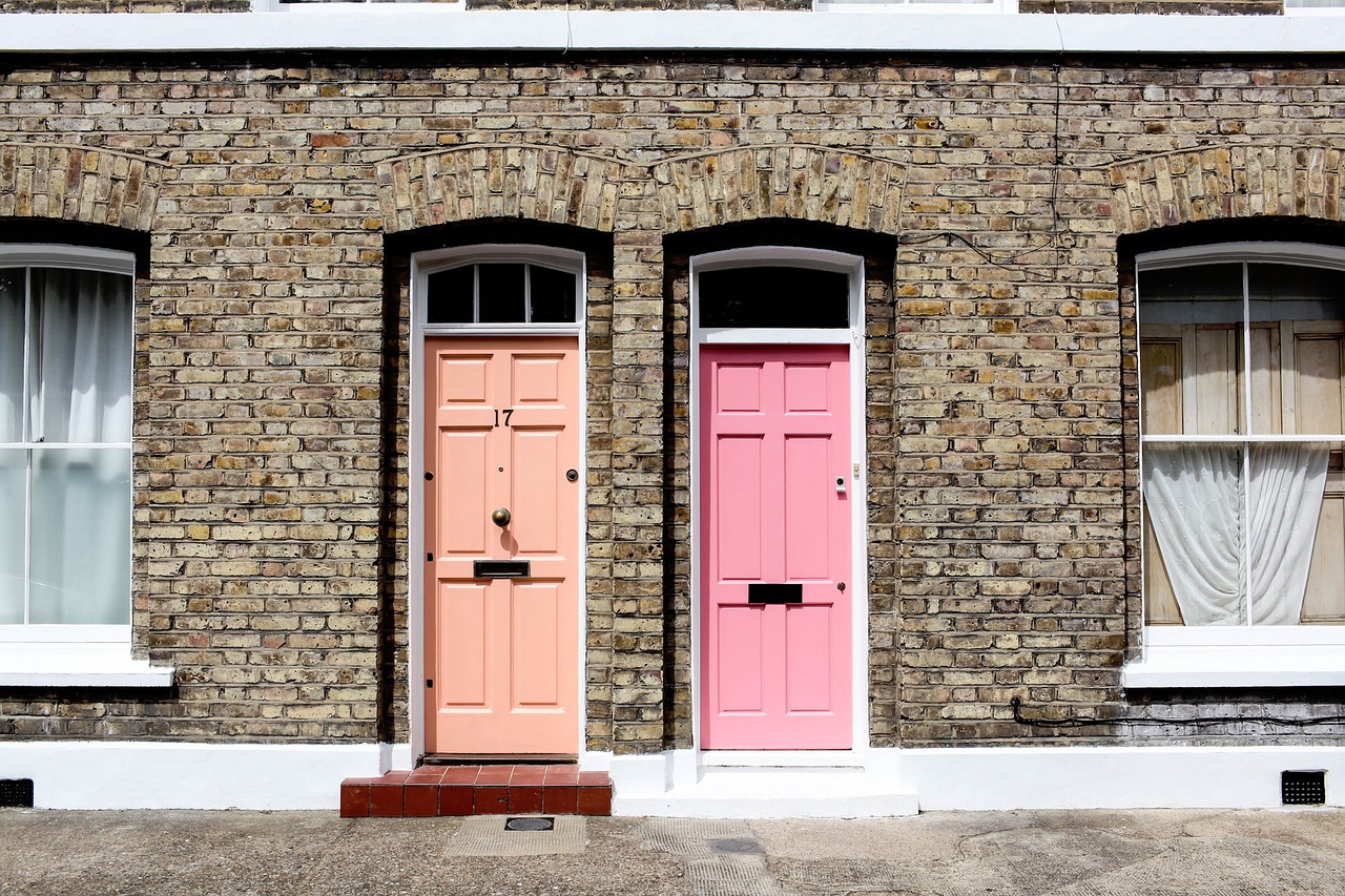 two pink doors in front of a brick building, by Samuel Scott, shutterstock, small houses, multi - coloured, two tone, male and female
