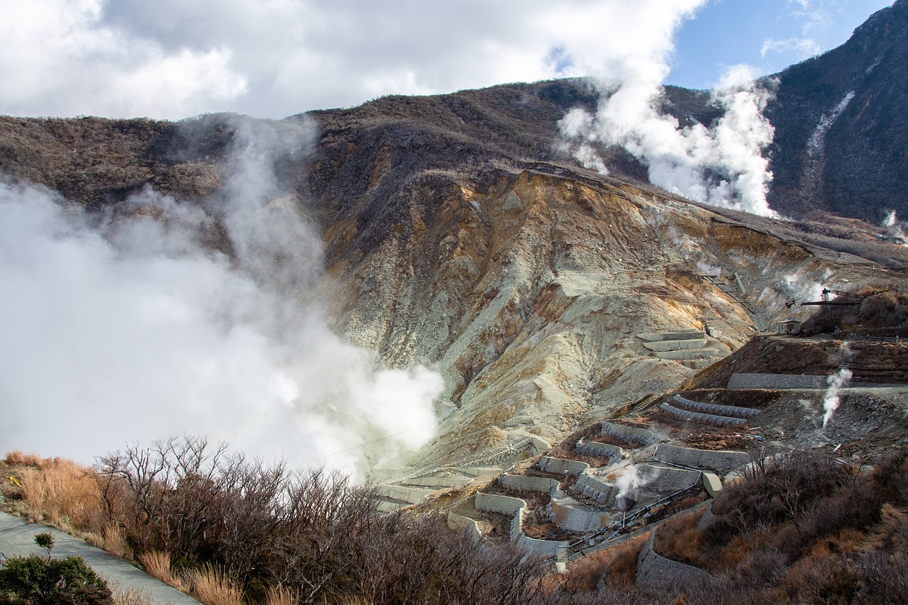a mountain that has steam coming out of it, by Gusukuma Seihō, flickr, iron smelting pits, terraces, 4k high res, side