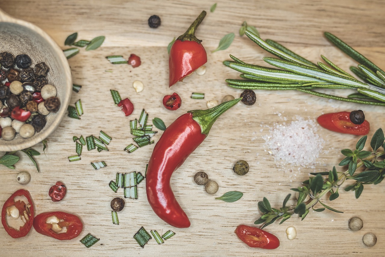 a wooden table topped with different types of spices, by Jakob Gauermann, pexels, ratatouille style, chili, detailed product photo, sickle