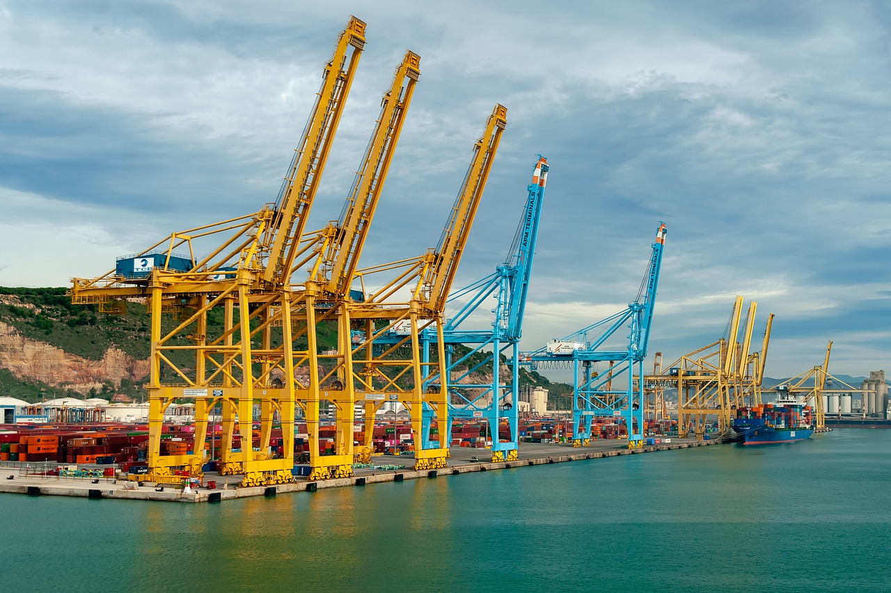 a group of cranes sitting on top of a body of water, a picture, shutterstock, port scene background, yellow and blue color scheme, platforms, portal