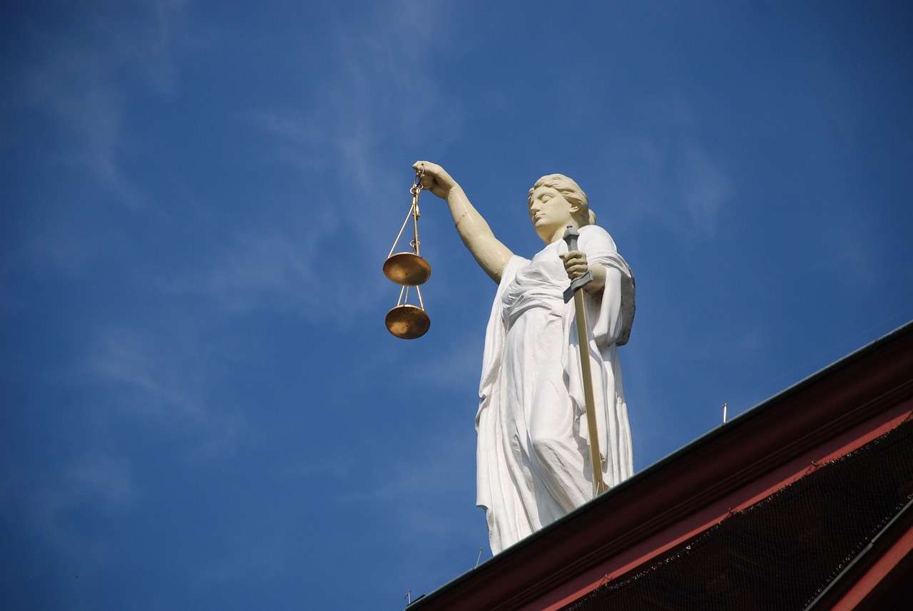 a statue of a lady justice holding a scale, a statue, figuration libre, outdoor photo, over - the - shoulder - shot, compressed jpeg, hires
