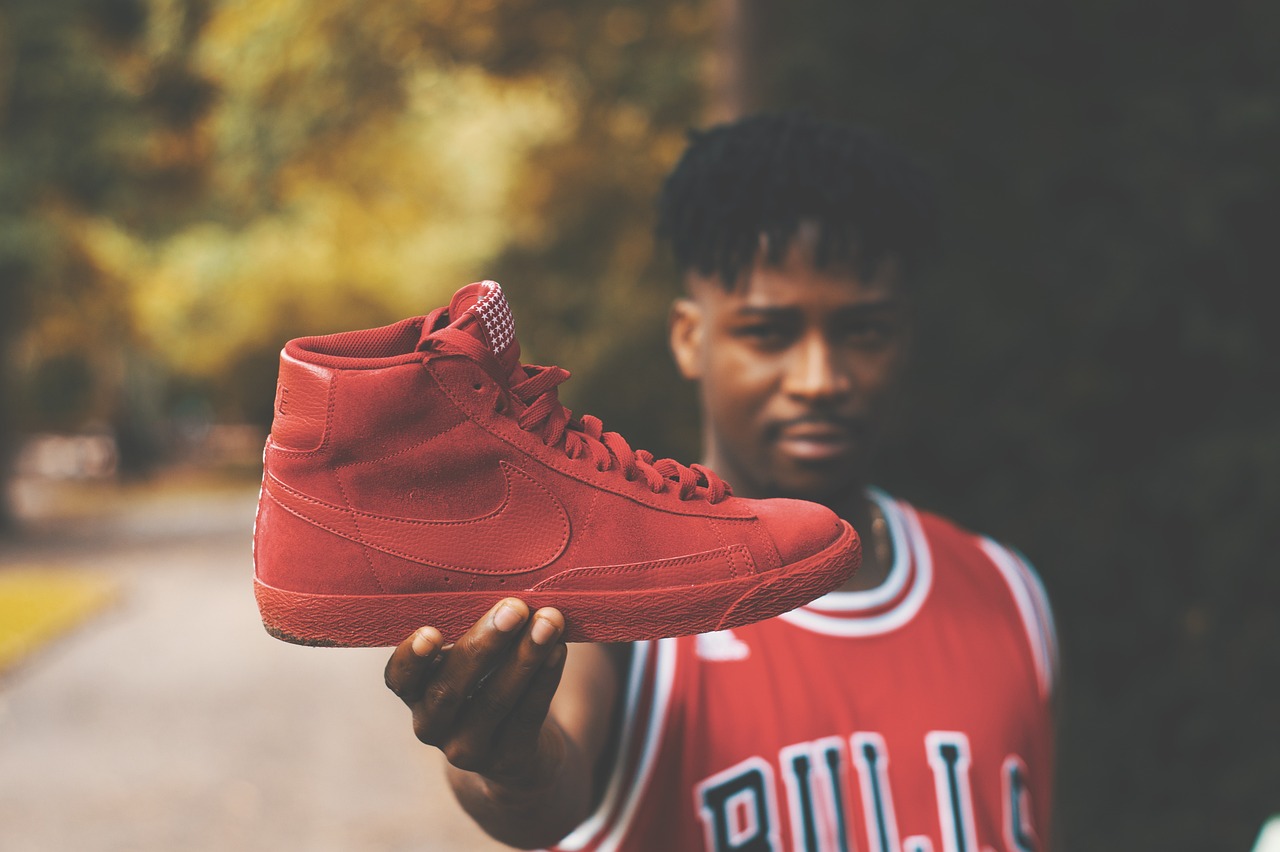 a close up of a person holding a shoe, inspired by Jordan Grimmer, pexels contest winner, red jacket, jaylen brown, ultra high quality model, stacks