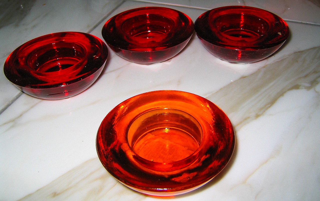 a group of red glasses sitting on top of a table, by Eugeniusz Zak, flickr, ashtray, orange color, holding a candle holder, panels