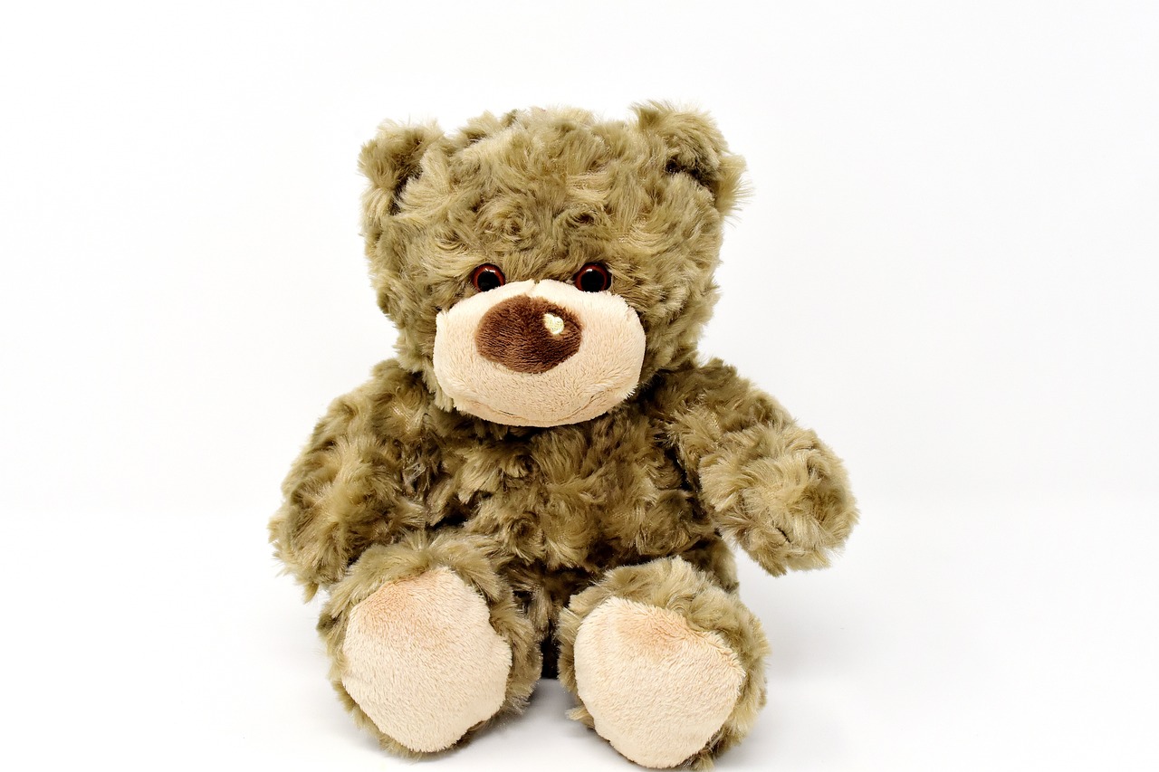 a brown teddy bear sitting on a white surface, a picture, hurufiyya, its name is greeny, smokey, full res, damaged