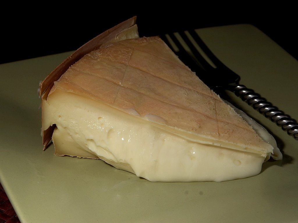 a piece of cheese on a plate with a fork, by Adam Chmielowski, flickr, renaissance, shiny skin”, chilean, pale - skinned, calatrava