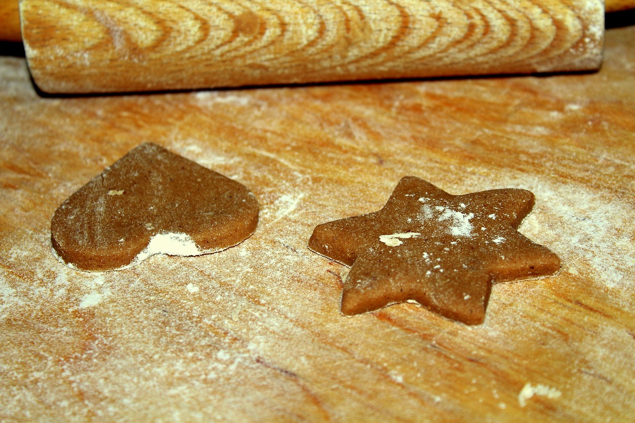 a couple of cookies sitting on top of a wooden table, pixabay, folk art, star inside, make it spicey, in the kitchen, slick!!