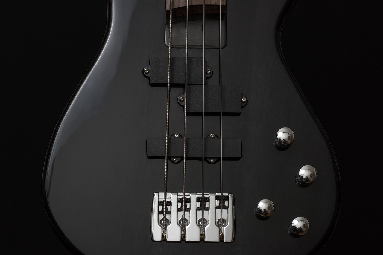 a close up of a bass guitar on a black background, by Jan Kupecký, shutterstock, bauhaus, streamlined matte black armor, on a gray background, rifles, closeup photo