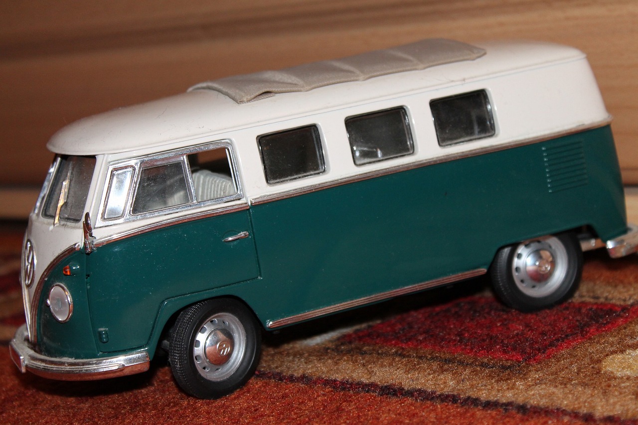 a green and white bus sitting on top of a rug, a picture, unsplash, photorealism, die - cast metal, with a roof rack, 1960, high detailed wheels