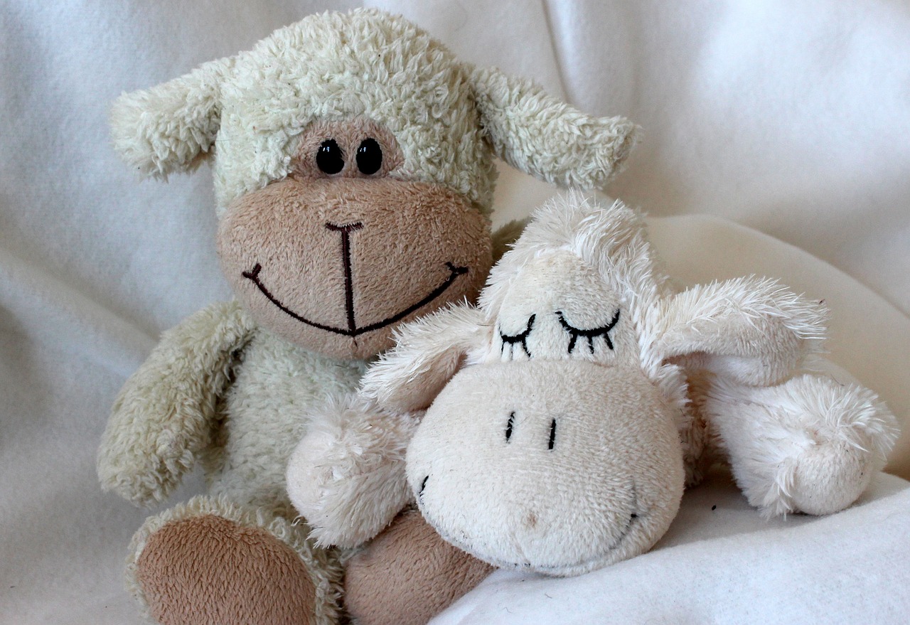 a couple of stuffed animals sitting next to each other, a picture, by Anita Kunz, pixabay, warm and gentle smile, lamb and goat fused as one, waking up, bottom angle