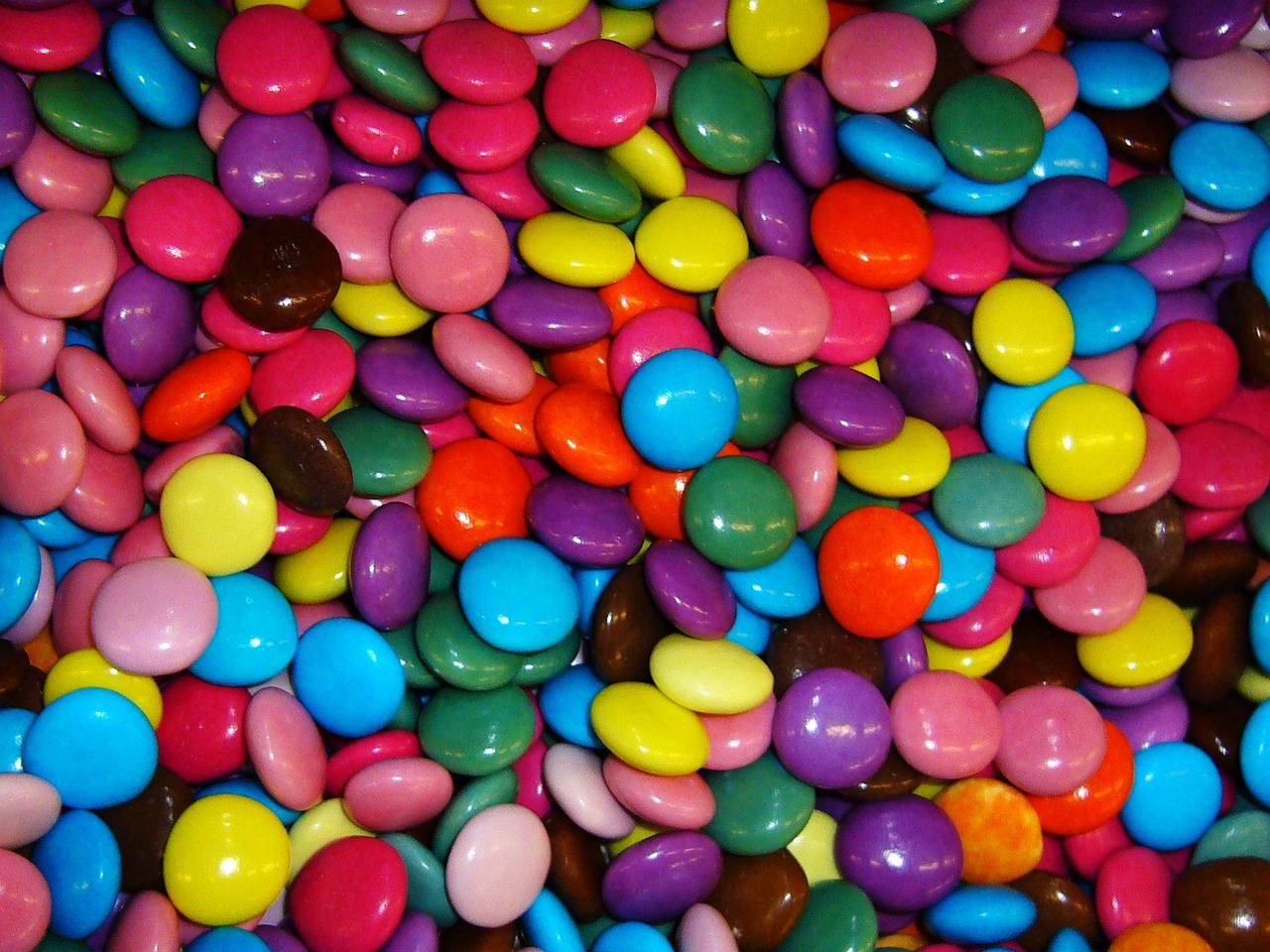 a pile of colorful candy sitting on top of a table, inspired by Damien Hirst, flickr, deep colours. ”, grain”, chocolate, colorful”