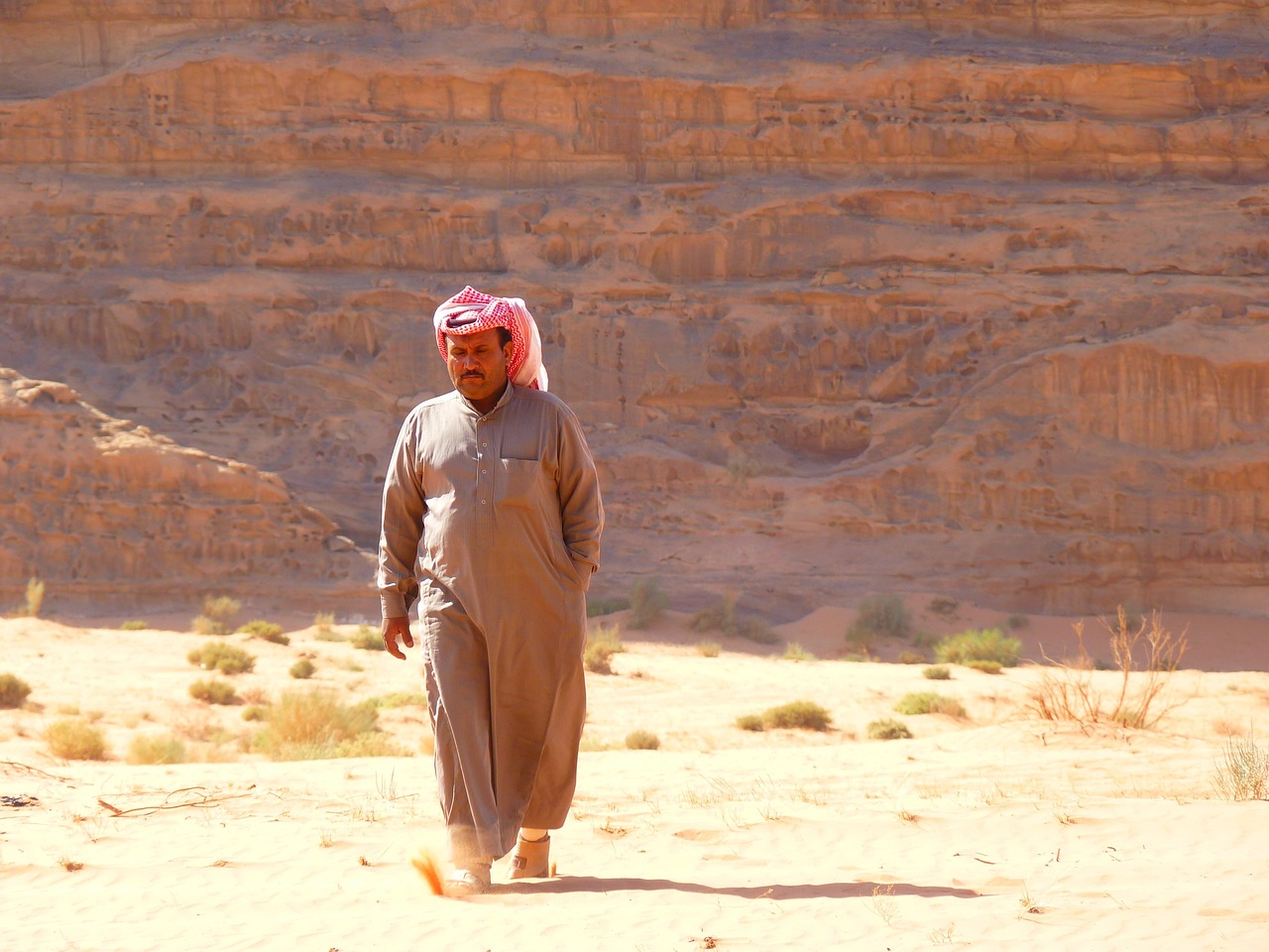 a man walking in the desert with a horse, inspired by Sheikh Hamdullah, draped in pink and green robes, he is about 7 0 years old, sandworm, pretty face!!