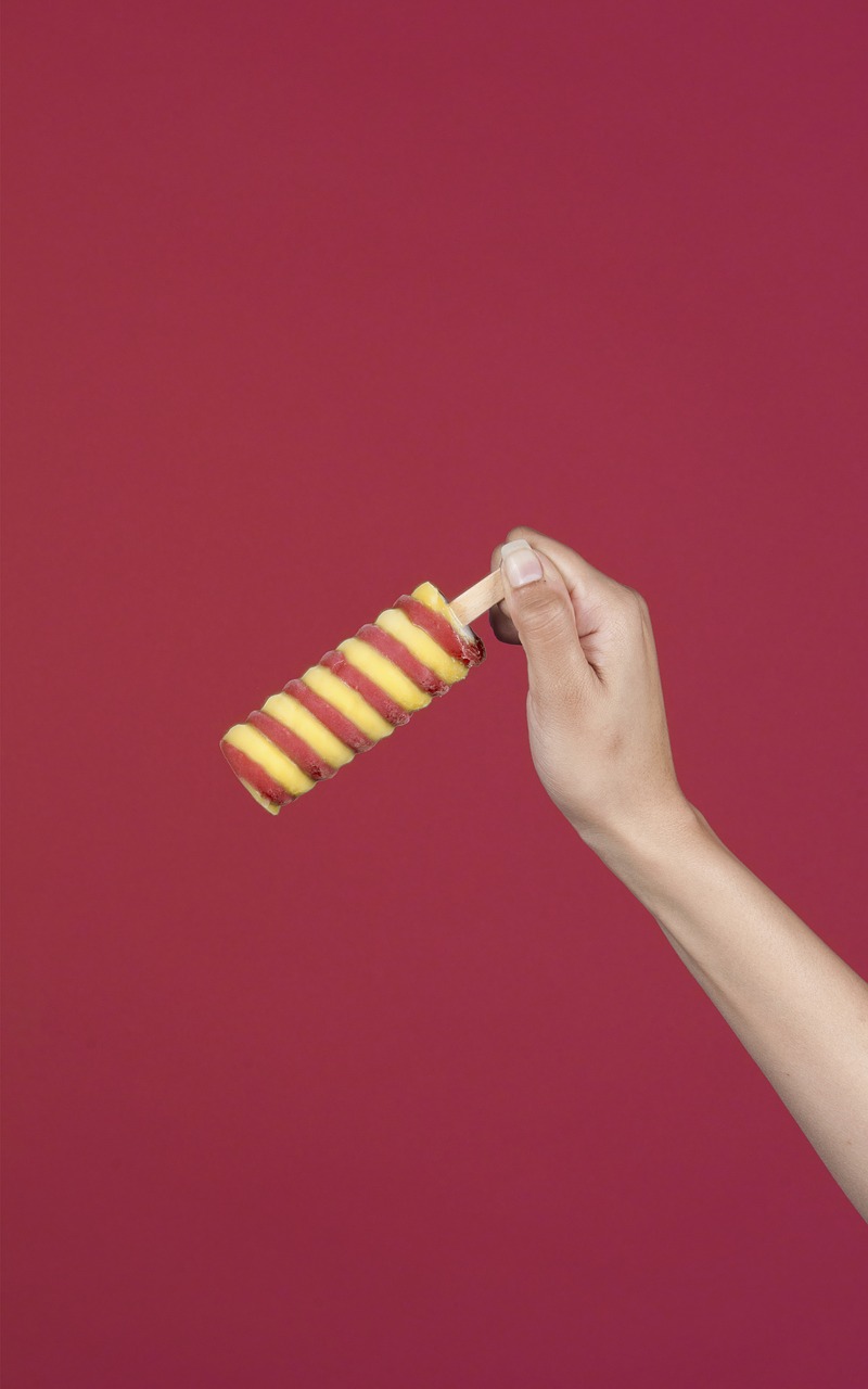 a person holding a candy cane in their hand, a picture, conceptual art, yellow and red color scheme, hotdogs, close-up product photo, ice cream