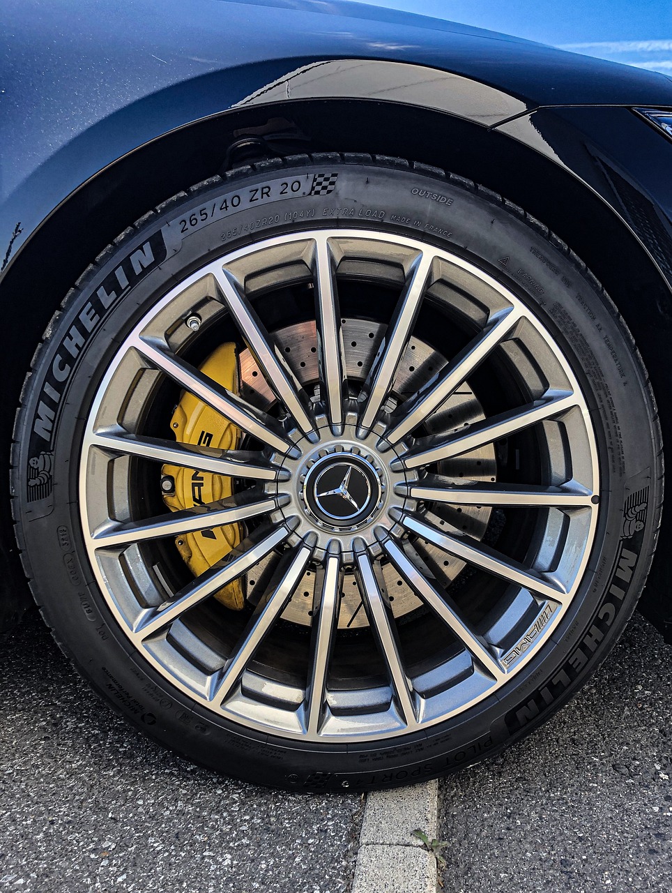 a close up of a tire on a blue car, a picture, by Tom Wänerstrand, mercedez benz, yellow and black trim, look at all that detail!, high detail photo