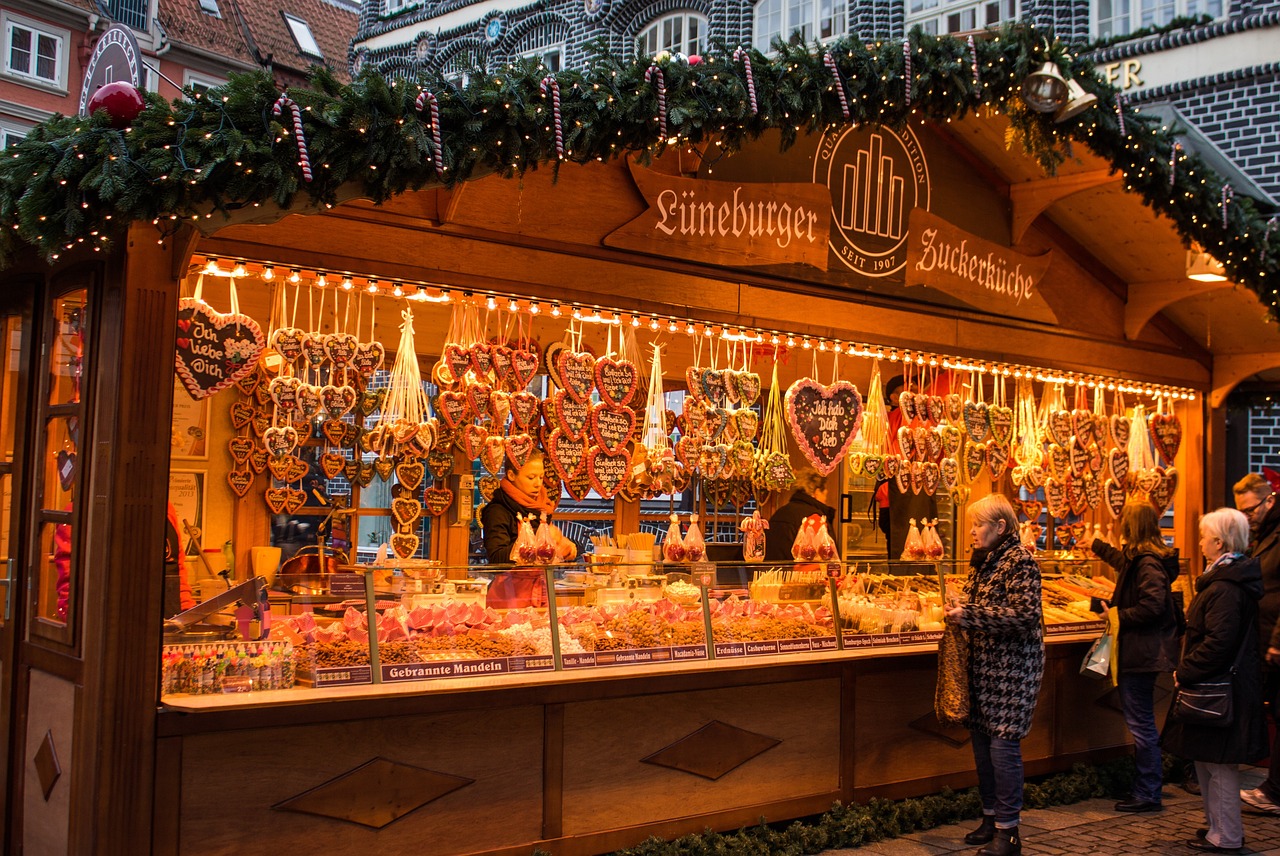 a group of people standing in front of a store, a photo, by Jakob Gauermann, shutterstock, gingerbread candy village, market stalls, germany. wide shot, ham