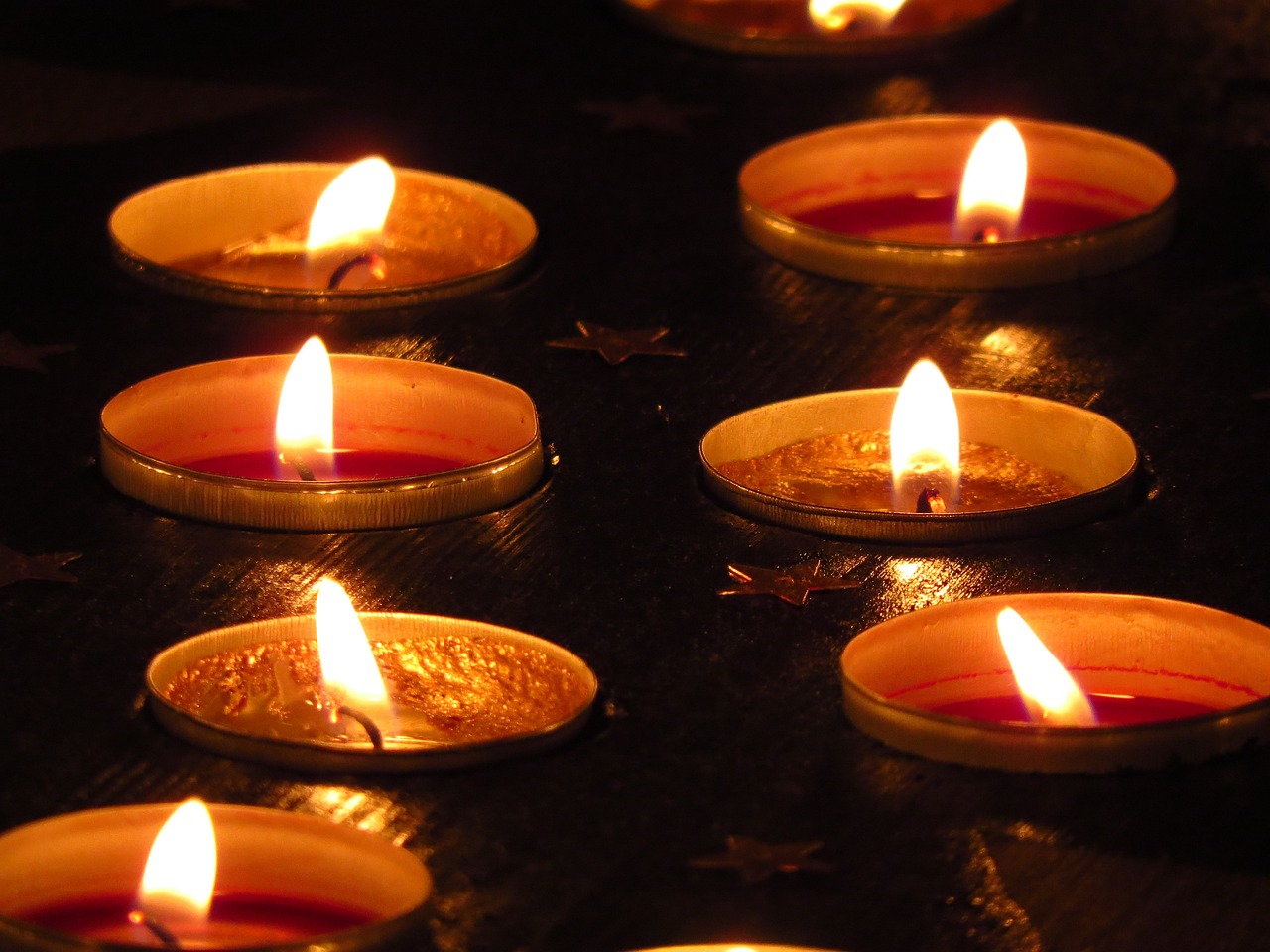 a group of lit candles sitting on top of a table, a picture, pexels, hurufiyya, detailed zoom photo, warm volumetric lights, wikimedia, full res