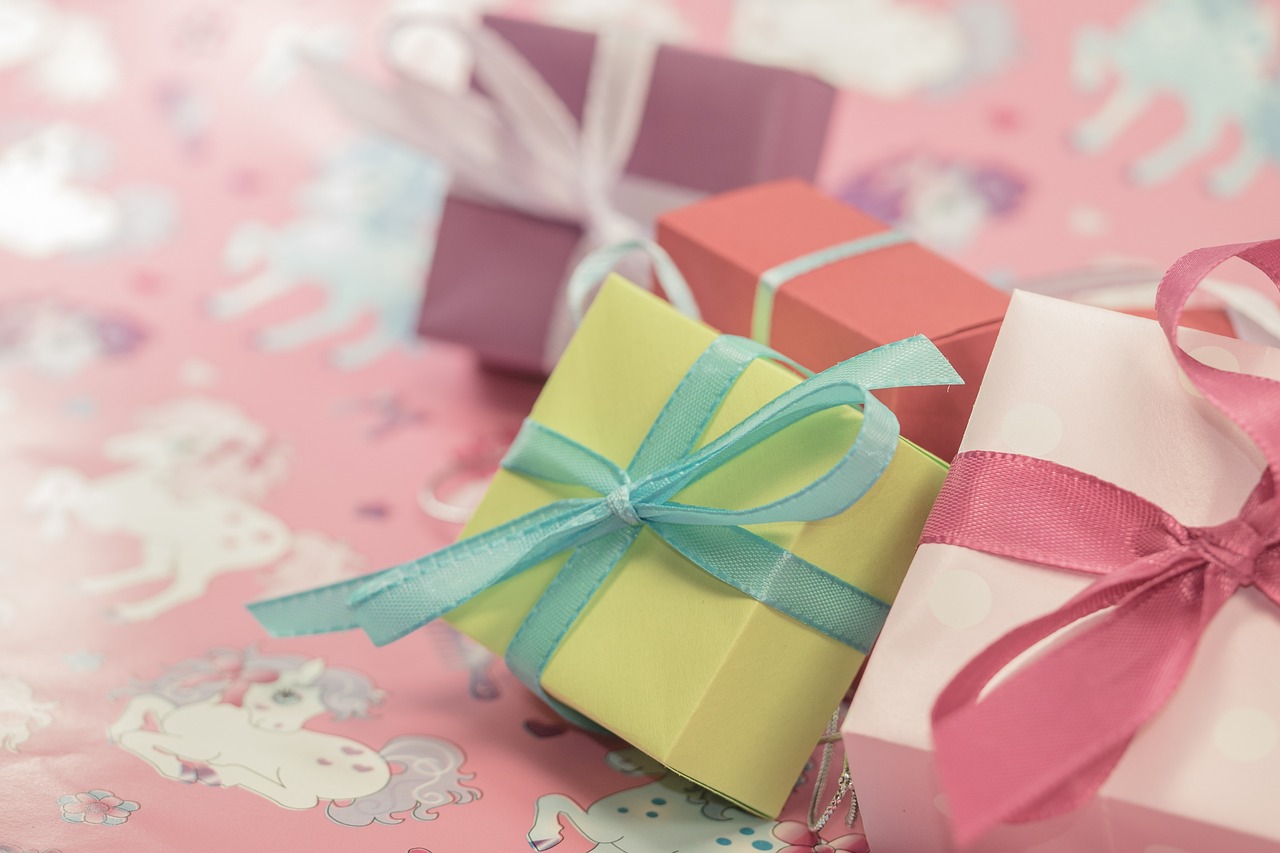 a couple of small boxes sitting on top of a table, a picture, by Alice Mason, shutterstock, kawaii colors, ribbon, stock photo, birthday