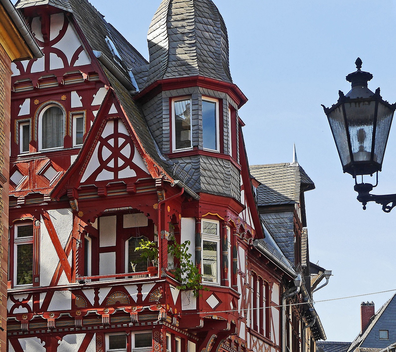 a red and white building with a street light in front of it, a photo, by Wilhelm Bendz, shutterstock, art nouveau, wooden houses, high - intricate - detail, germany. wide shot, medieval town