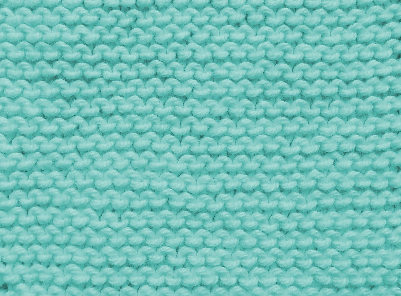 a close up of a blue knitted blanket, a digital rendering, close-up product photo, textured turquoise background, high detail product photo, real photo