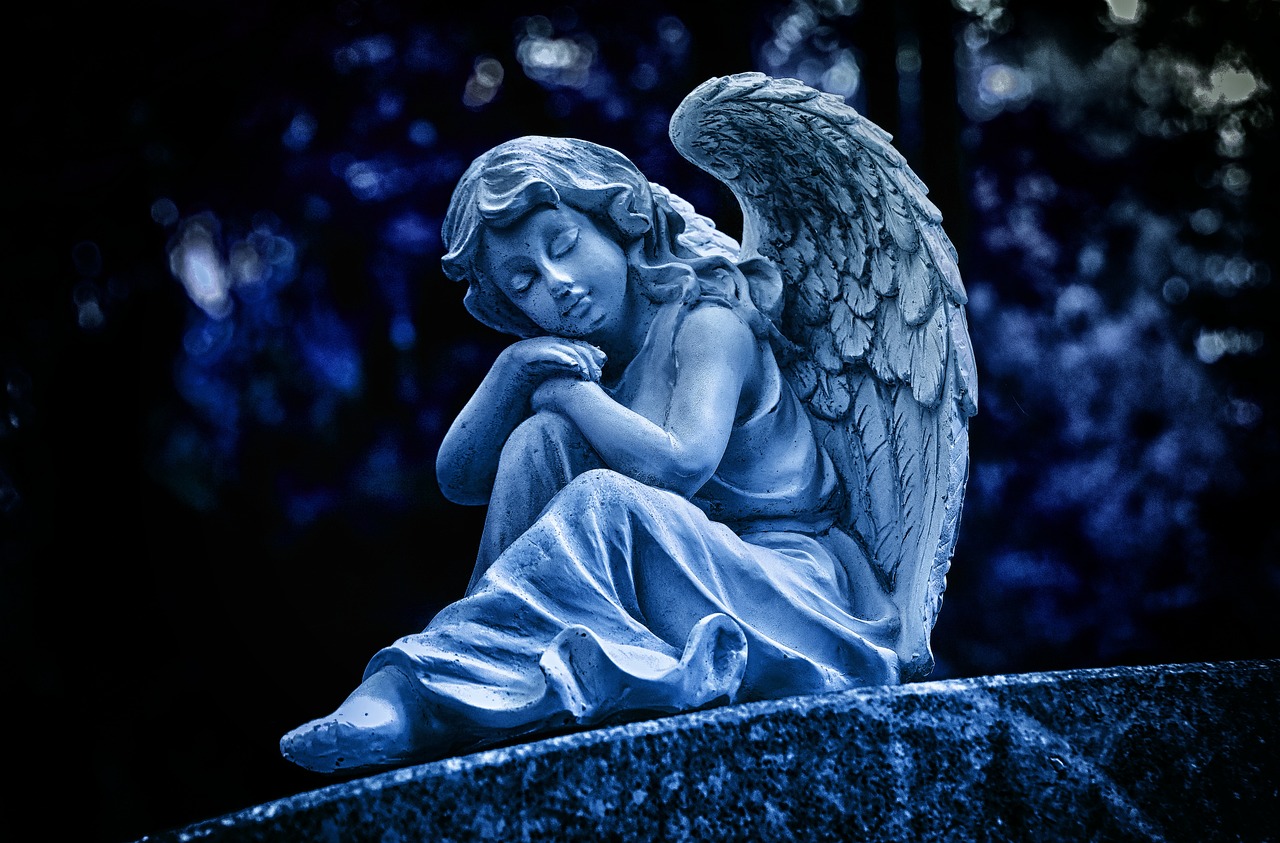 a statue of an angel sitting on top of a stone, fine art, blue toned, sitting in a cemetery at night, grand angel wings, resting on a pillow