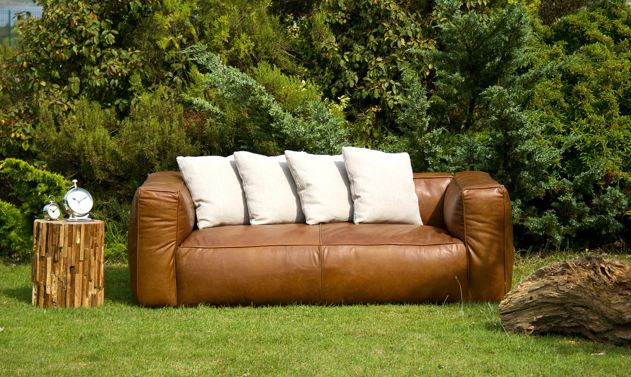 a brown leather couch sitting on top of a lush green field, bauhaus, high quality product photo, white pillows, high detail product photo, attractive and good looking